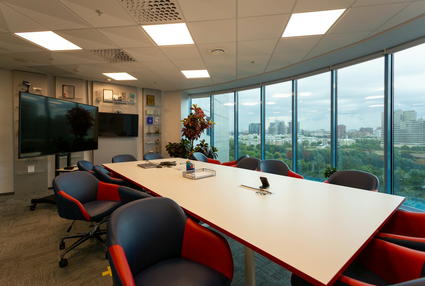 Empty modern conference room with city skyline views through windows.