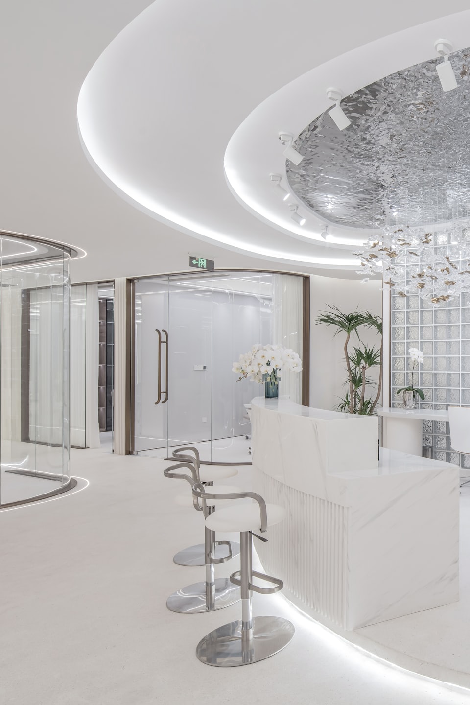 Modern office reception area with marble desk and plants.